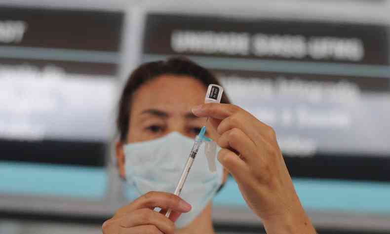 Enfermeira segurando seringa com vacina da COVID 