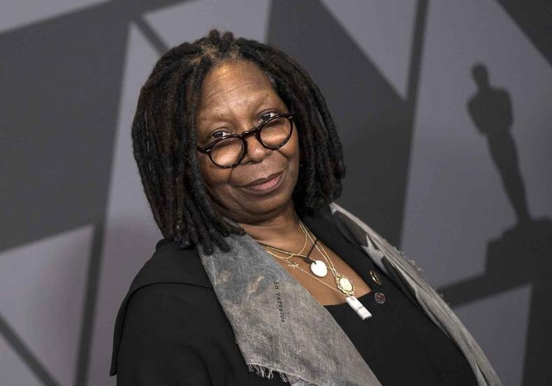 Atriz Whoopi Goldberg olha para a c�mera em cen�rio em tons de cinza 