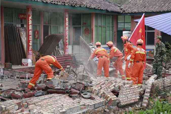 Bombeiros procuram vtimas em meio a escombros de fbrica destruda pelo terremoto(foto: REUTERS/China Daily )