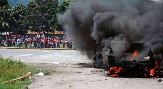 STR / AFP(foto: Carro de campanha de Henrique Capriles foi incendiado por apoiadores de Chvez )
