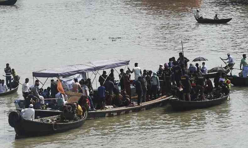 Bombeiros do grupo de resgate procuram corpos de passageiros da balsa que afundou em rio de Bangladesh(foto: Munir UZ ZAMAN / AFP)