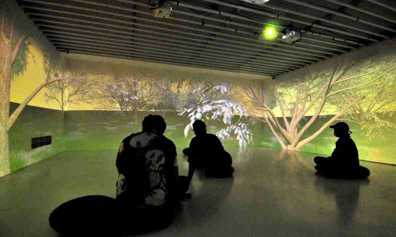 trs vultos humanos em ambiente que simula floresta estilizada em exposio na galeria do Minas Tnis Clube 