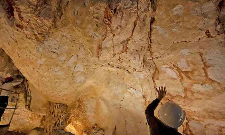 Homem observa desenhos rupestres que podem ter 33 mil anos feitos em caverna maritima francesa