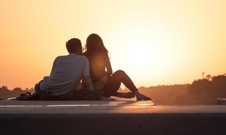 Casal olhando o por-do-sol