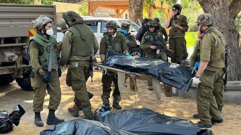 Hamas invadiu o vilarejo de Kfar Aza, incendiando casas e matando seus moradores(foto: Oren Rosenfeld) Corpos são recolhidos em kibbutz