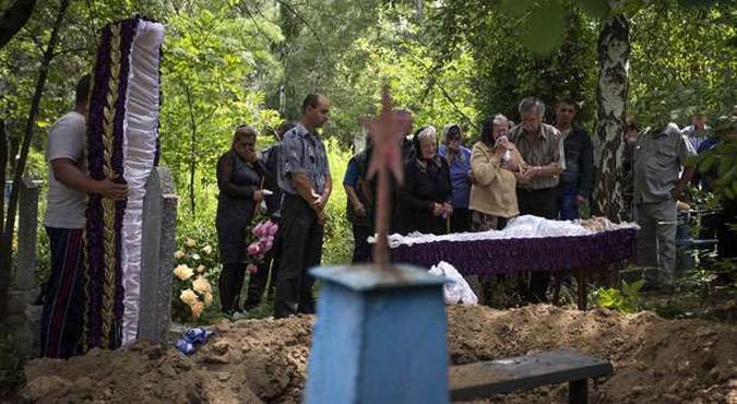 Família enterra corpo de parente morto em bombardeio na cidade de Pryvillya, na região de Lugansk, leste do país(foto: Shamil Zhumatov/Reuters) Família enterra corpo de parente morto em bombardeio na cidade de Pryvillya, na região de Lugansk, leste do país(foto: Shamil Zhumatov/Reuters)