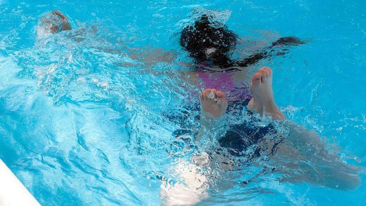 Águas agitadas por menina nadando em piscina