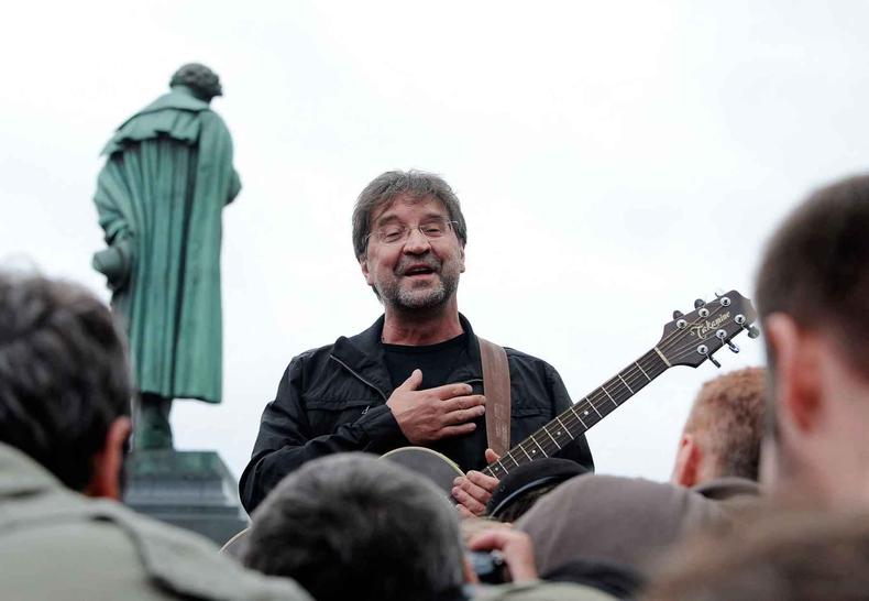 O roqueiro russo Yuri Shevchuk segura a guitarra e pe a mo no peito durante show em Moscou