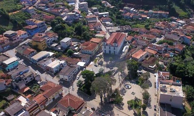 Vista rea de Senador Firmino com a Igreja e uma praa em destaque