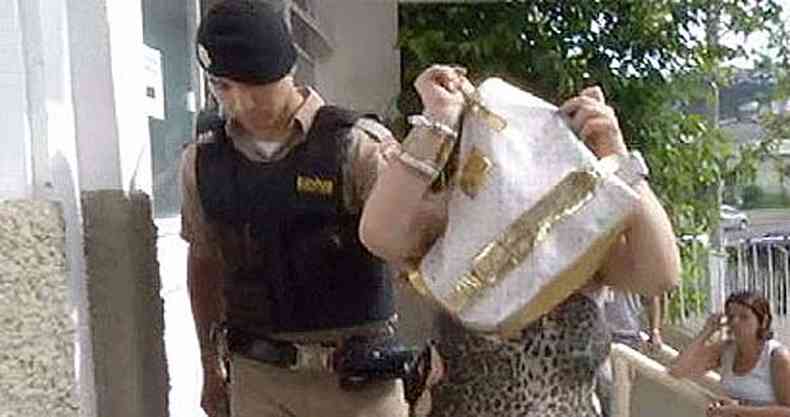Quando foi presa a mulher escondeu o rosto dentro da bolsa ao chegar na delegacia(foto: TV Alterosa/Reproduo)