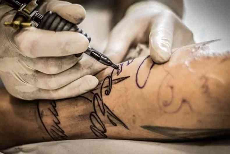 Tatuagem  feita em brao acima da mesa 
