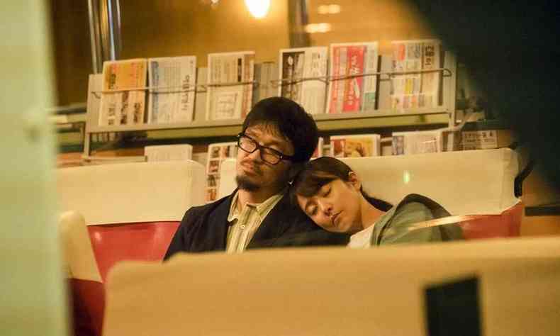 Casal dorme sentado numa biblioteca em cena do filme Love life