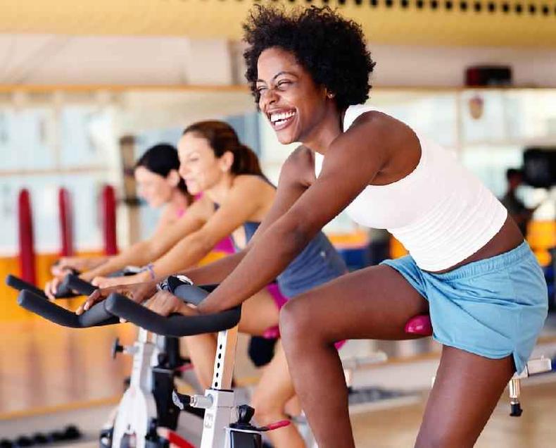 A prática regular de exercícios pode ajudar a alterar a composição das bactérias intestinais(foto: Getty Images) Mulheres pedalando na academia