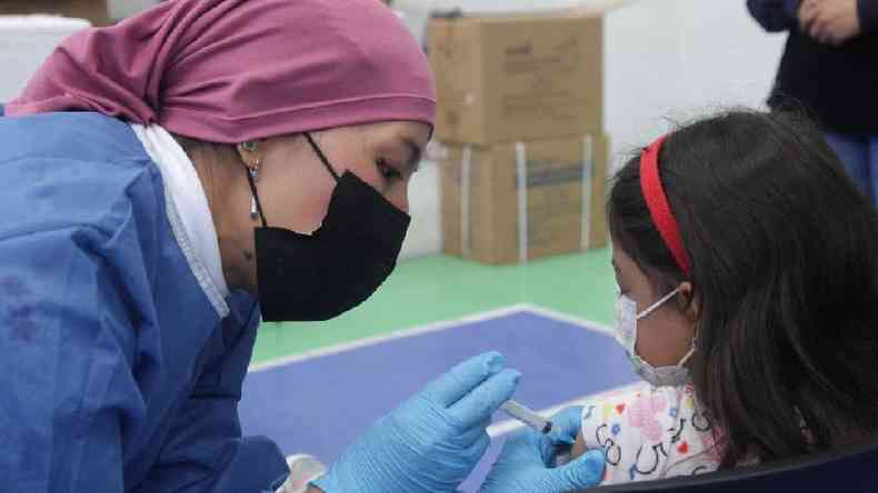Enfermeira vacina criana no Equador