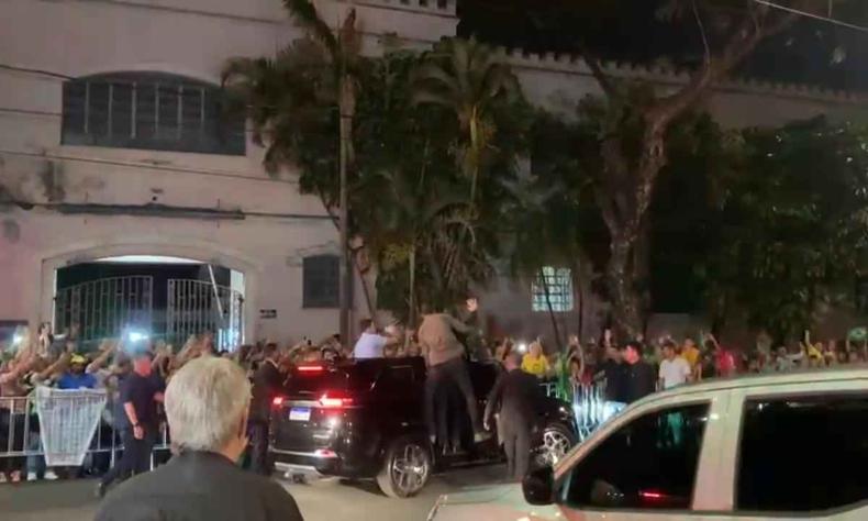 Eleitores do presidente marcaram presença nos arredores do Teatro Sesiminas, na Região Leste de BH(foto: Mariana Costa) Jair Bolsonaro em cima de um carro acena para apoiadores