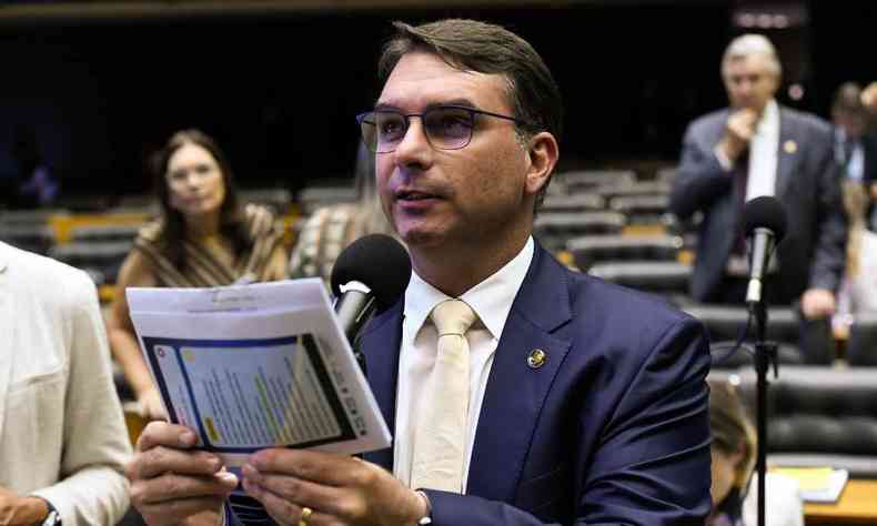 Flvio Bolsonaro segura papel diante de pulpito do plenrio
