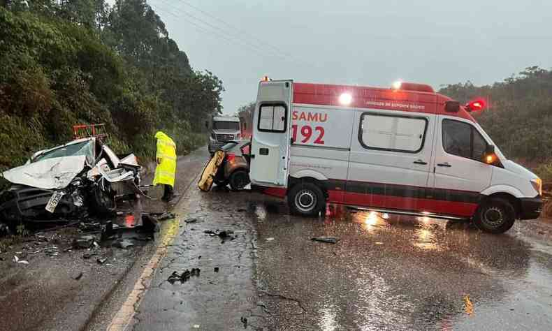 Pista molhada, com ambulncia, vista pela lateral, atravessada na rodovia. Carro destrudo s margens da BR-129