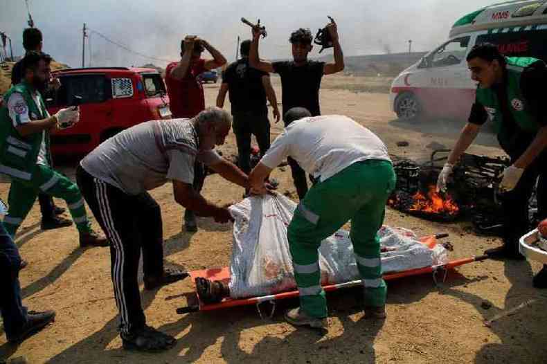 Paramdicos transportam os corpos de dois jovens palestinos cuja motocicleta foi atacada perto da cerca da fronteira entre a Faixa de Gaza e Israel 
