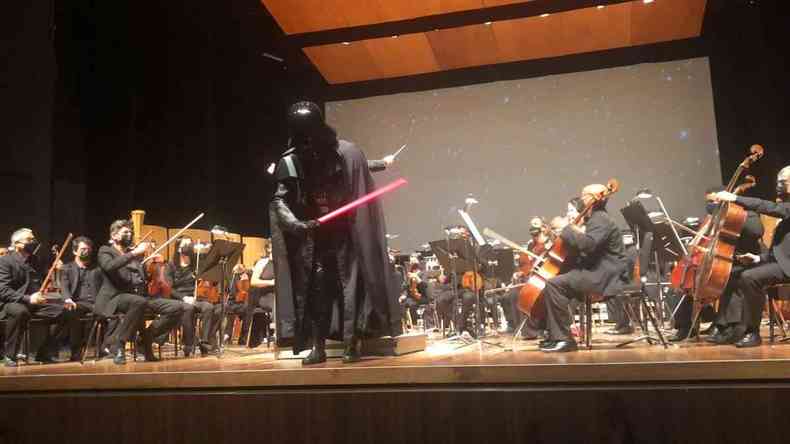 Homem fantasiado de Darth Vader rege a Sinfônica de Minas, no palco do Cine Brasil, em BH 