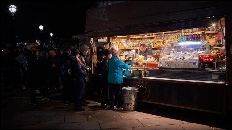 Pessoas fazendo compras em uma barraca de feira