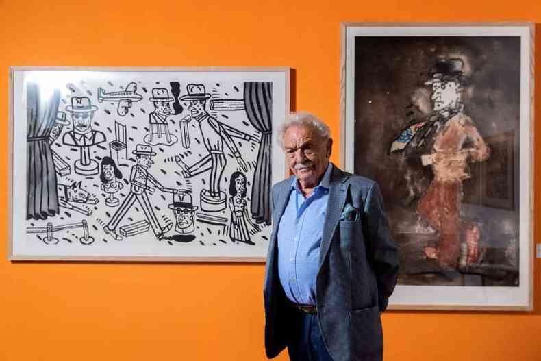 Pintor argentino Antonio Segu em frente a dois de seus quadros