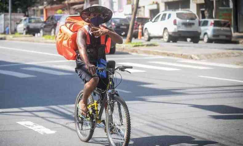 Entregador usa mscara enquanto se desloca de bicicleta pela cidade (foto: Leandro Couri/EM/DA Press)