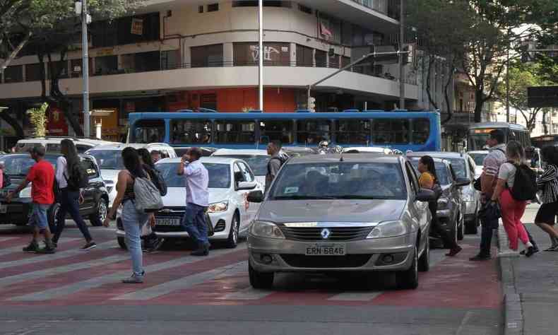 carros em cima da faixa de pedestre da cor vermelha 