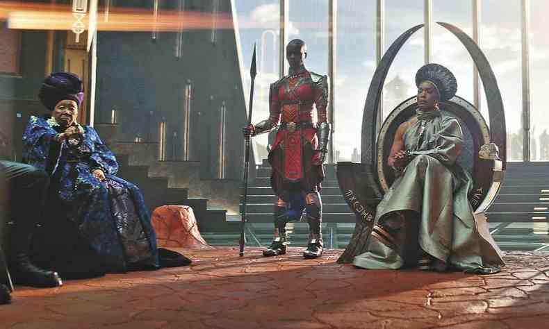 Atriz no papel de Ramonda ocupa o trono de Wakanda, cercada por dois seguranas, em cena de Wakanda para sempre
