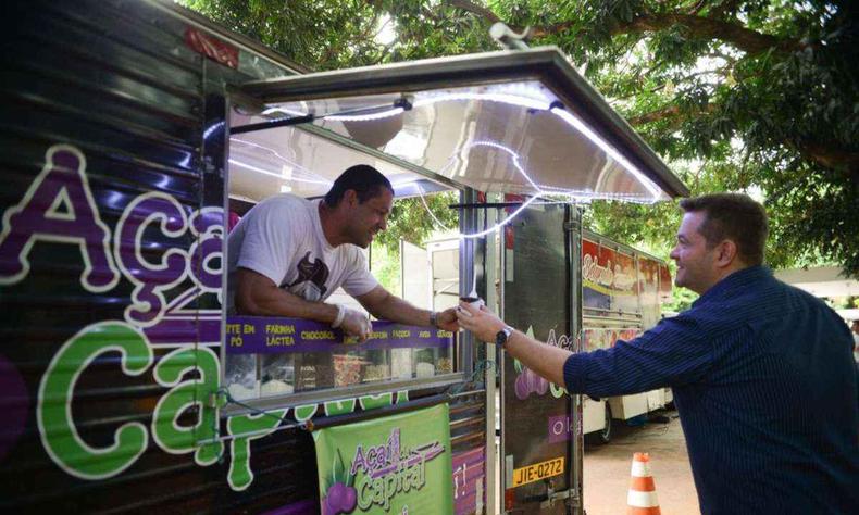 Food truck de aa, atendente entrega produto para cliente