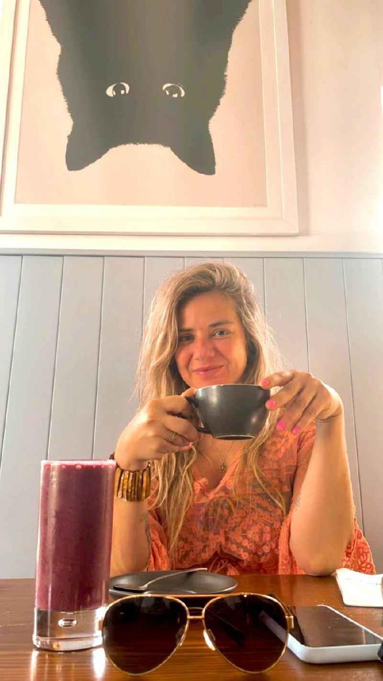 Amanda Munaretti Selbach sentada com uma xcara na mo