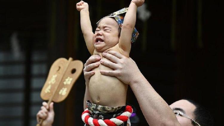 Homem levanta beb nos braos no Japo