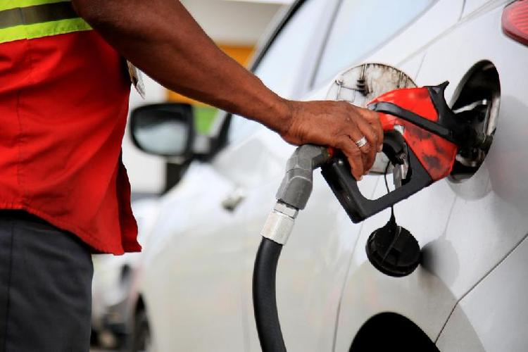 Funcionrio de posto de gasolina colocando combustvel em carro