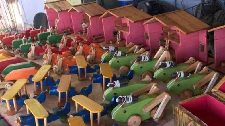 brinquedos de madeira expostos antes de doao. Existem nas cores rosa, verde, azul e amarelo