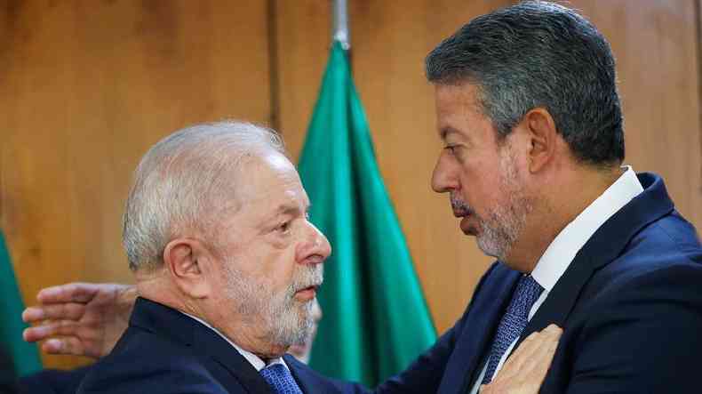 Lula e Lira se cumprimentando com abraos em sala 