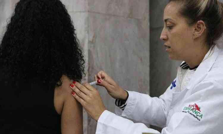 Mdica aplicando vacina em uma mulher 