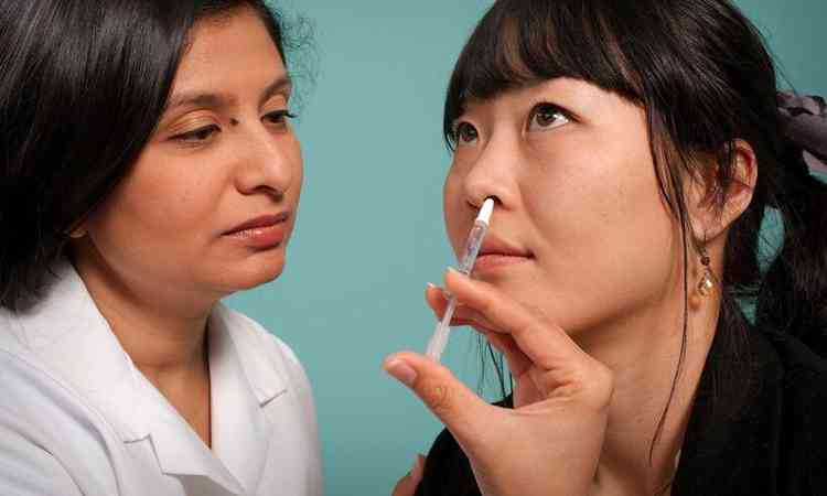 mdico lava nariz de paciente com uma seringa
