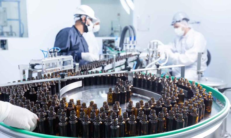 Com sede em Belo Horizonte, empresa é a única farmacêutica especializada em cannabis a produzir o medicamento no Brasil(foto: Ease Labs/Divulgação) Vários frascos do remédio com pessoas trabalhando ao redor