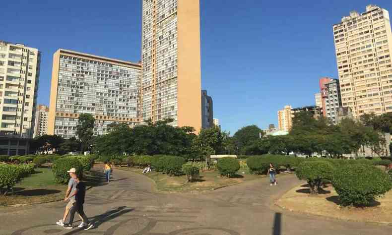 Tempo aberto e céu azul com pessoa caminhando na Praça Raul Soares no Centro de Belo Horizonte entre os prédios e edifícios