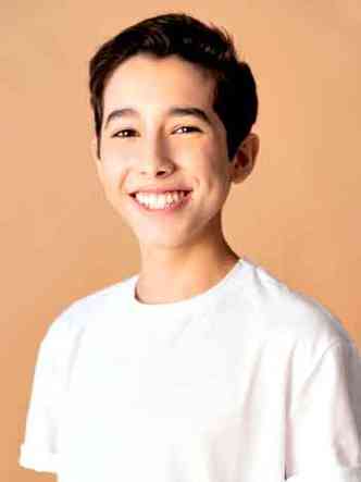 Usando camiseta branca, o ator Joo Pedro Delfino, de 15 anos, sorri para a cmera