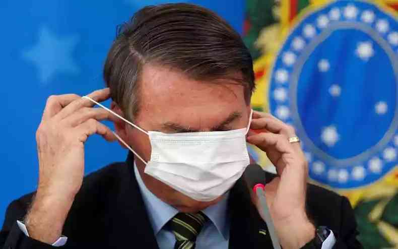 Bolsonaro se embola ao colocar mscara de preveno contra o coronavrus