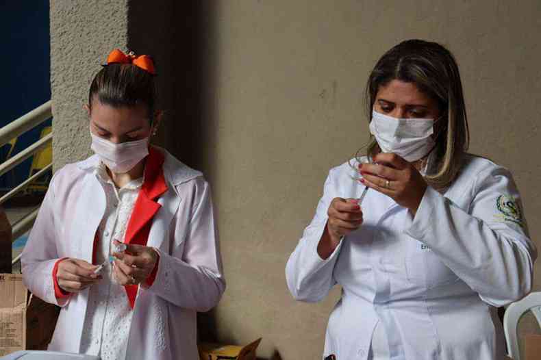 profissionais da sade preparam seringas para aplicao de dose da vacina contra COVID