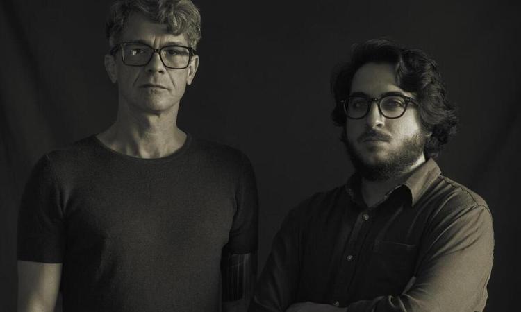 Celso Sim e Joo Camarero, de p, olham para a cmera