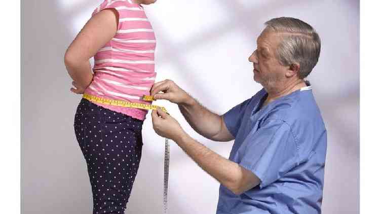 Foto mostra mdico medindo a circunferncia abdominal de uma criana