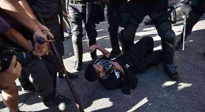 Policiais rendem manifestante em protesto antes do jogo final da Copa(foto: AFP PHOTO / YASUYOSHI CHIBA)