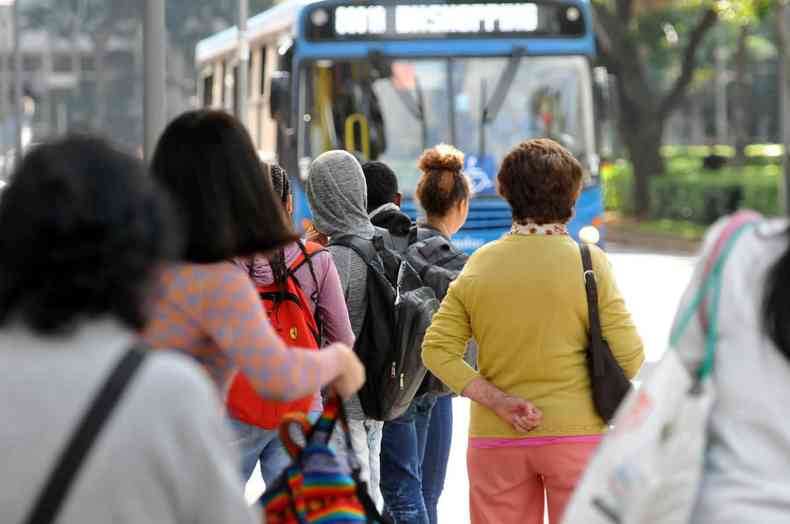 Passageiros estão em um ponto de ônibus em Belo Horizonte e esperam um coletivo