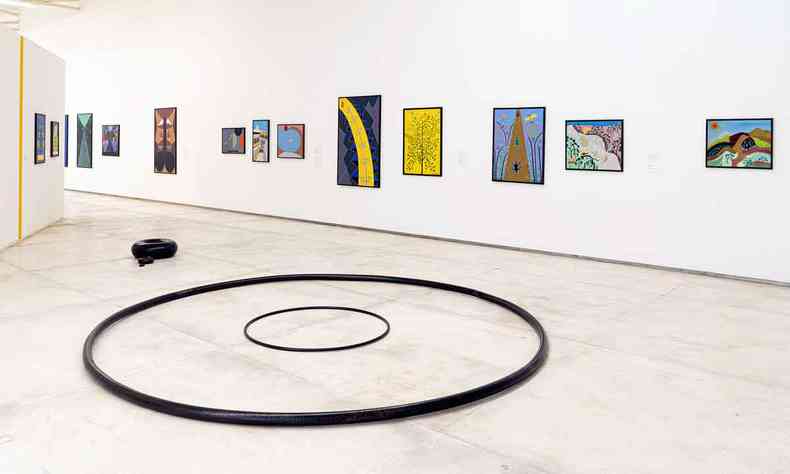 Quadros na parede e instalação circular, no meio da galeria, na exposição Abdias Nascimento, Tunga e Museu de Arte Negra, em Inhotim