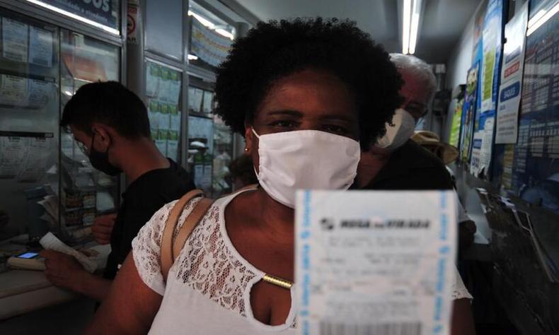 Emilia Goreti segurando o bilhete da aposta na Mega da Virada