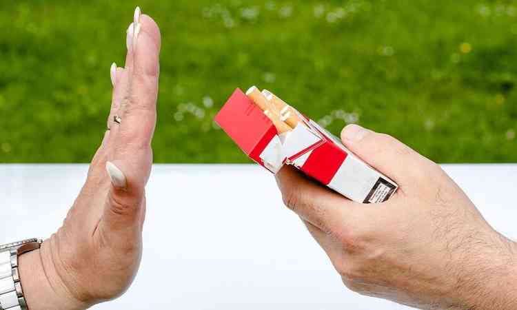 Homem oferece cigarro para uma mulher, que recusa
