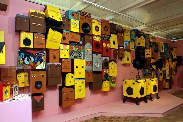 Sala com diversas caixas de som pintadas com rostos de personagens 
