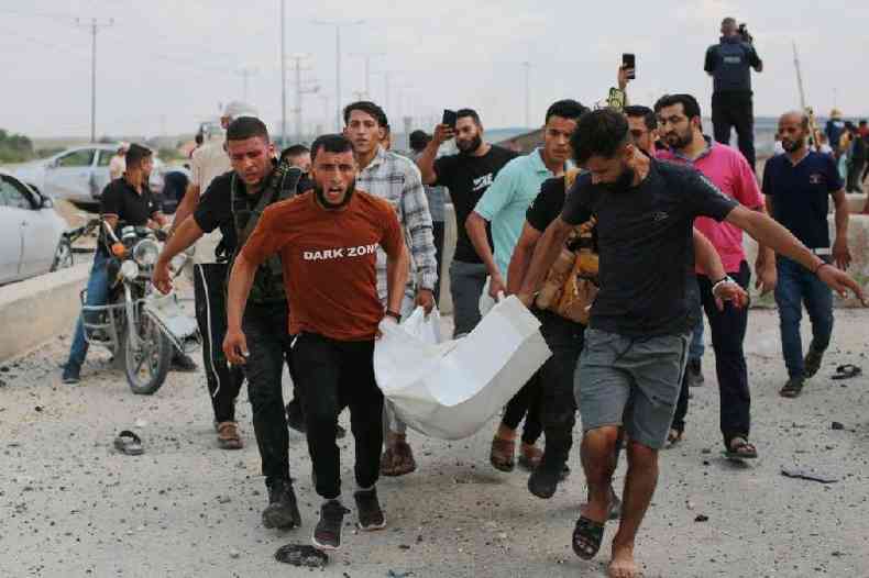 Homens palestinos carregam uma vtima aps um ataque areo israelense na passagem de Erez entre Israel e o norte da Faixa de Gaza
